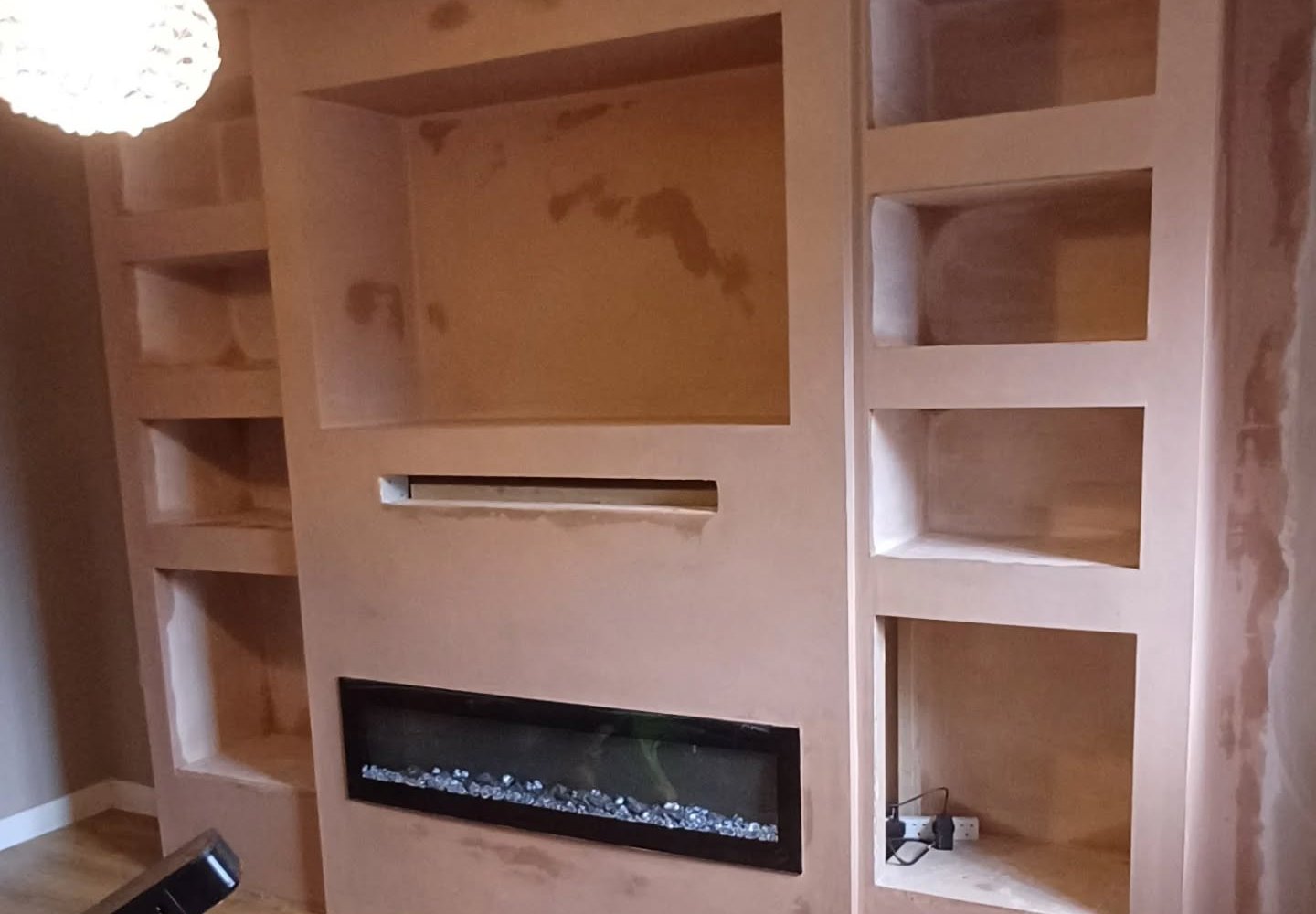 Media wall with fireplace and shelving freshly plastered by JB Plastering